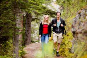 A happy man and woman hiking on a camping trip