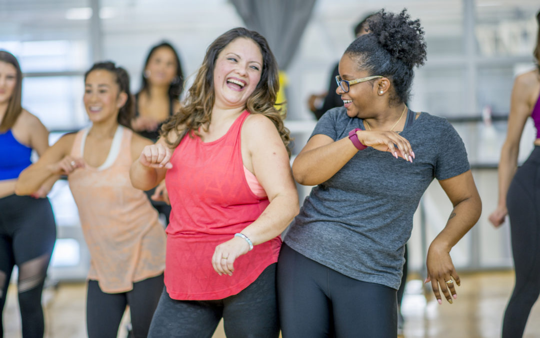 People smiling while dancing in a fitness class