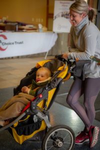Person chatting with an infant in a stroller
