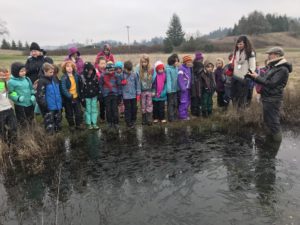 Group of children standing at the edge of a pond