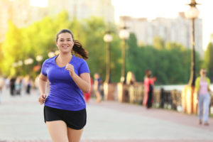 Person smiles while jogging on a sunny day