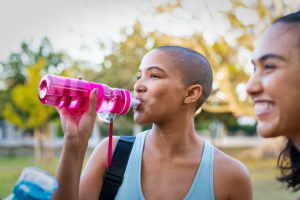 Person drinks from a waterbottle after an exercise class