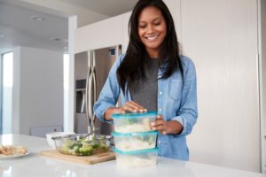 Person prepares healthy meals in containers for lunches